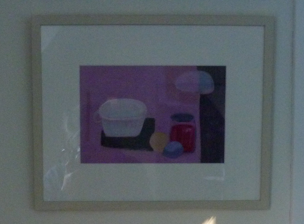 Still life with white cup, jar of jam and sliced up lemon. Pale pink background with purple stripe on right hand side