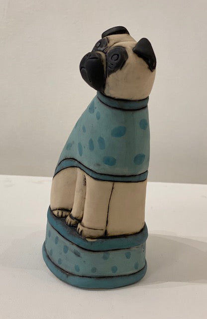 quirky pug dog ceramic sculpture with green coat and base by Anna Noel at Iona House Gallery