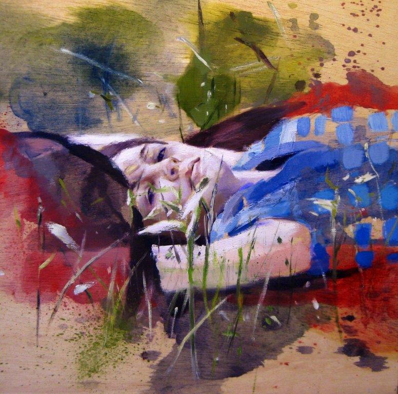 Woman lying flat on the ground, arms above her head. She has long dark hair and is wearing a blue top. She is looking into the eyes of the viewer.